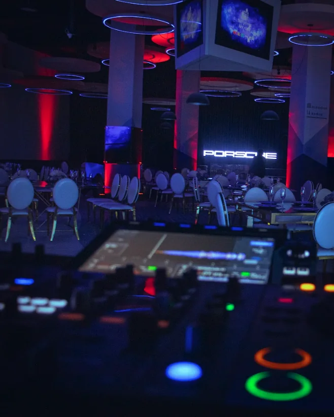Escenario para eventos con ambientación audiovisual y mesas montadas